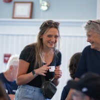 GVSU Alumnae smile at each other in the Alumni House & Visitor Center